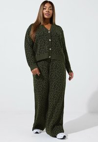 Olivgrüner Strickcardigan und passende weit geschnittene Hose mit schwarzem Leopardenmuster, mit Knopfverschluss und gerippten Bündchen.