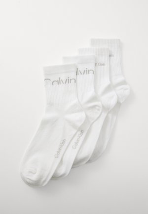 Four pairs of white cotton socks with ribbed cuffs. "Calvin Klein" printed in light gray on the sides. Soft texture, ankle-length design.