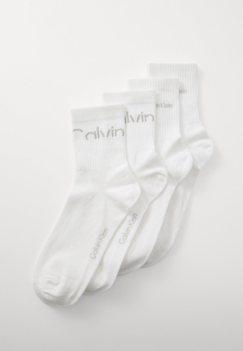 Quatro pares de meias de algodão brancas com punhos canelados. "Calvin Klein" impresso a cinza claro nas laterais. Textura suave, design até ao tornozelo.