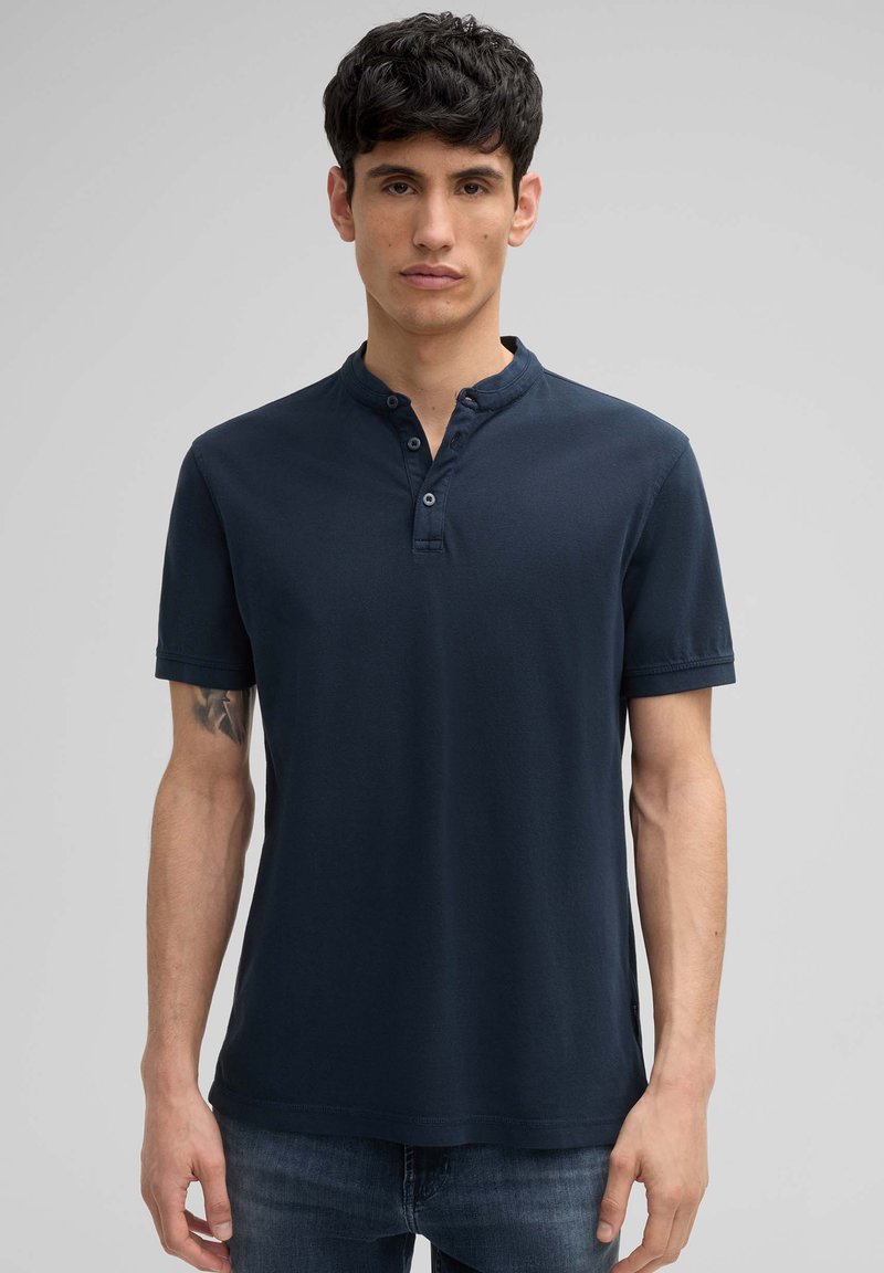 Polo shirt bleu marine avec un col henley à boutons, des manches courtes et une texture douce. Fabriqué en tissu respirant, offrant une coupe décontractée.