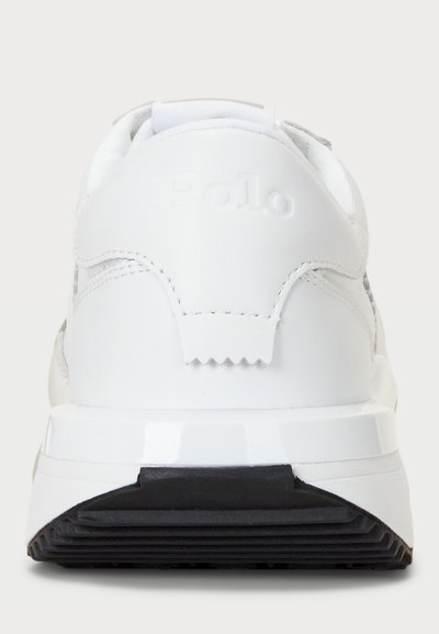 Λευκά αθλητικά παπούτσια με υφή δερμάτινης επένδυσης, λείες λεπτομέρειες, επωνυμία στη φτέρνα και ανθεκτική μαύρη ελαστική σόλα. Απλός, μοντέρνος σχεδιασμός.