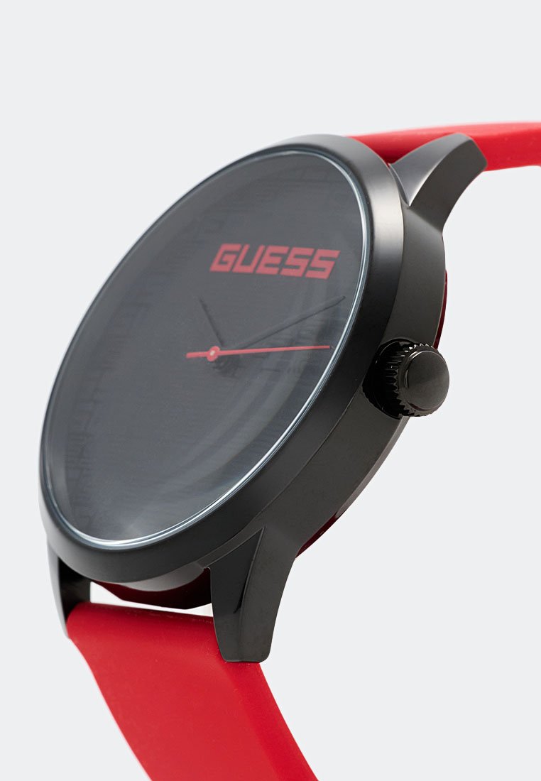 Reloj circular negro con esfera de cristal transparente. Esfera y manecillas rojas, correa de silicona roja y caja negra con acentos texturizados.