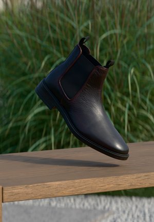 Schwarze Leder Chelsea-Boots mit strukturiertem Finish, elastischen seitlichen Einsätzen und Schlaufe. Robuste Sohle und elegantes, spitz zulaufendes Design.