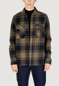 Camicia a quadri con una combinazione di colori verde scuro, nero e beige. Realizzata in tessuto morbido, con due tasche sul petto e chiusura con bottoni.