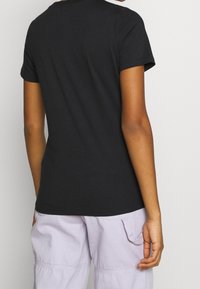 Svart kortärmad t-shirt i bomull med rund halsringning, med en slät yta och en ren, minimalistisk design.