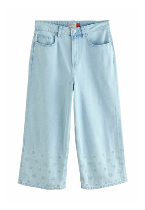 Lyseblå jeans med vide ben og kort længde, med lommer foran og bagpå, knap- og lynlåslukning samt blomsterbroderi med hulmønster nær kanterne.