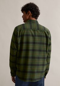 Πράσινο καρό πουκάμισο φλις με μαύρα και πορτοκαλί καρό σχέδια, μακρυά μανίκια και κολάρο με κουμπιά, με χαλαρή εφαρμογή και καμπυλωτό στρίφωμα.