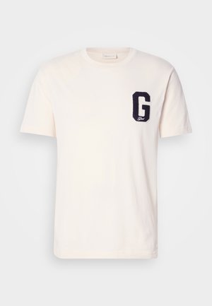 Weißes T-Shirt mit kurzen Ärmeln und Rundhalsausschnitt, mit einem marineblauen Buchstaben "G" Patch auf der linken Brust.