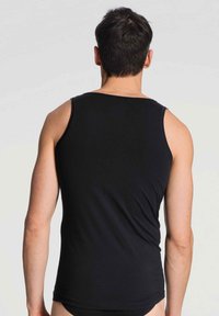 Zwarte mouwloze tanktop gemaakt van zacht materiaal. Voorzien van een ronde halslijn en een snug fit, met minimale stikseldetails. Achteraanzicht getoond.