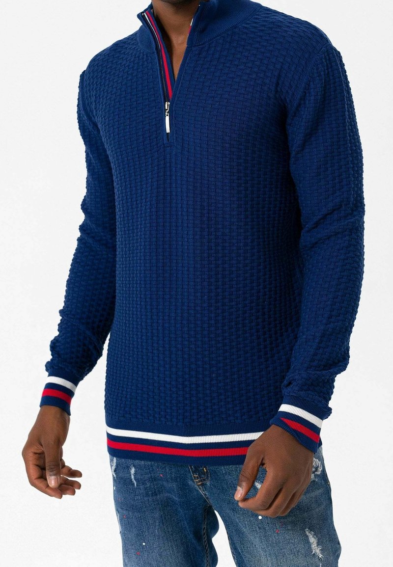 Maglione pullover blu navy con motivo testurizzato, collo a zip a un quarto e polsini a righe con coste. Realizzato in tessuto lavorato a maglia.