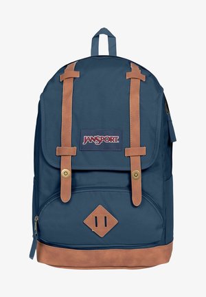 Zaino blu navy con dettagli in pelle, dotato di chiusura a pattina, tasca frontale e spallacci regolabili. Accessori in metallo dorato visibili.