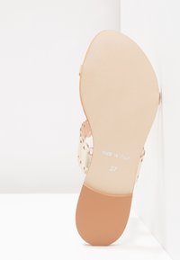 Sandale beige avec un design de lanières perforées, semelle plate, marquée "FABRIQUÉ EN ITALIE" et taille "37" au bas.