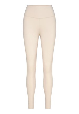 Beige high-waisted legging met lange pijpen, naadloze voorkant en aansluitende pasvorm, getoond op een effen witte achtergrond.