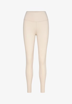 Beige high-waisted legging met lange pijpen, naadloze voorkant en aansluitende pasvorm, getoond op een effen witte achtergrond.