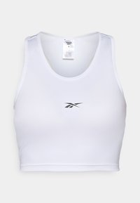 Top sportiv alb, scurt, fabricat dintr-un material neted, cu un gât rotund și un mic logo Reebok negru pe față.