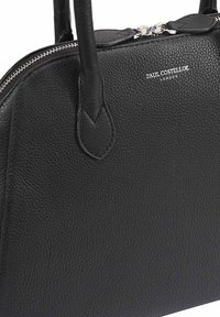 Sac à main en cuir noir texturé avec deux poignées et double fermeture éclair argentée, marqué "Paul Costelloe London" à l'avant.