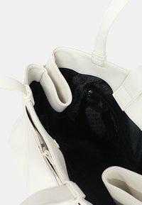 Borsa tote in pelle bianca con texture e interno nero. Dispone di molteplici scomparti e di una tasca con cerniera. Manici rinforzati.