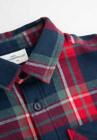 Flanelowa koszula w kratę w kolorach czerwonym, zielonym i granatowym, z kołnierzykiem, ciemnymi guzikami i detalami kieszeni. Miękka w dotyku o klasycznym wzorze w kratę.