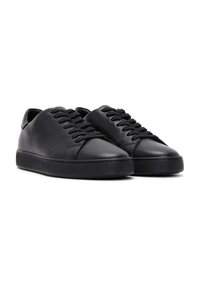 Zapatillas de cuero negro con textura suave, punta redonda y suela de goma plana. Presentan cordones negros y un diseño minimalista.
