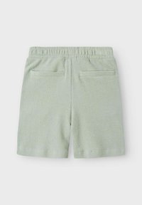 Shorts vert clair en tissu texturé, dotés d'une taille élastique et de deux poches arrière. Le design est simple et classique.