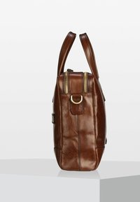 Bolso de cuero marrón con dos asas, forma rectangular, costuras visibles y un detalle de cremallera dorada en la parte superior.