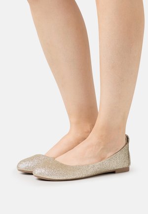 Ballerines en paillettes dorées avec un bout arrondi et un petit talon. Texture lisse, finition douce et une légère découpe à l'arrière.