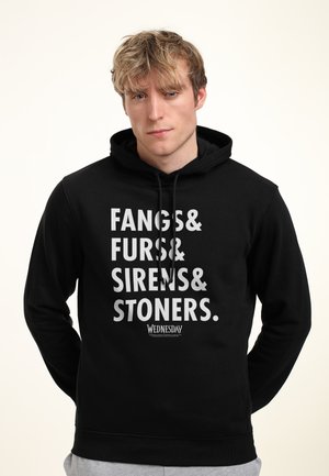 Felpa nera realizzata in morbido tessuto con grande scritta bianca: "FANGS& FURS& SIRENS& STONERS." con un logo più piccolo "WEDNESDAY" in basso.