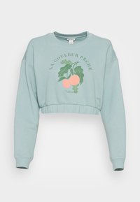 Sudadera recortada de color verde claro con mangas largas, que presenta un diseño gráfico de melocotón y texto. Tejido suave con dobladillos y puños acanalados.