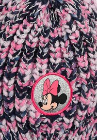 Beanie lavorata a maglia in filato rosa, blu navy e bianco con fili argentati. Presenta una toppa rotonda con un personaggio dei cartoni animati.