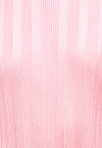 Πλεκτό τοπ σε ανοιχτό ροζ με κάθετη ριμπ υφή. Διαθέτει ομοιόμορφα κατανεμημένες οριζόντιες γραμμές και λείο φινίρισμα.