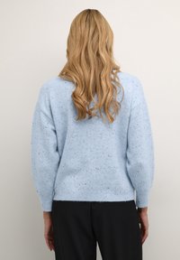 Jasnoniebieski sweter dziany w kropki o luźnym kroju, z okrągłym dekoltem i długimi rękawami, wykonany z miękkiego, przyjemnego w dotyku materiału.