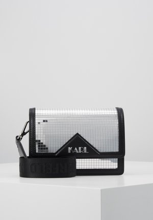 Small rectangular silver crossbody bag with black trim, black adjustable strap, and "KARL" logo on front flap.