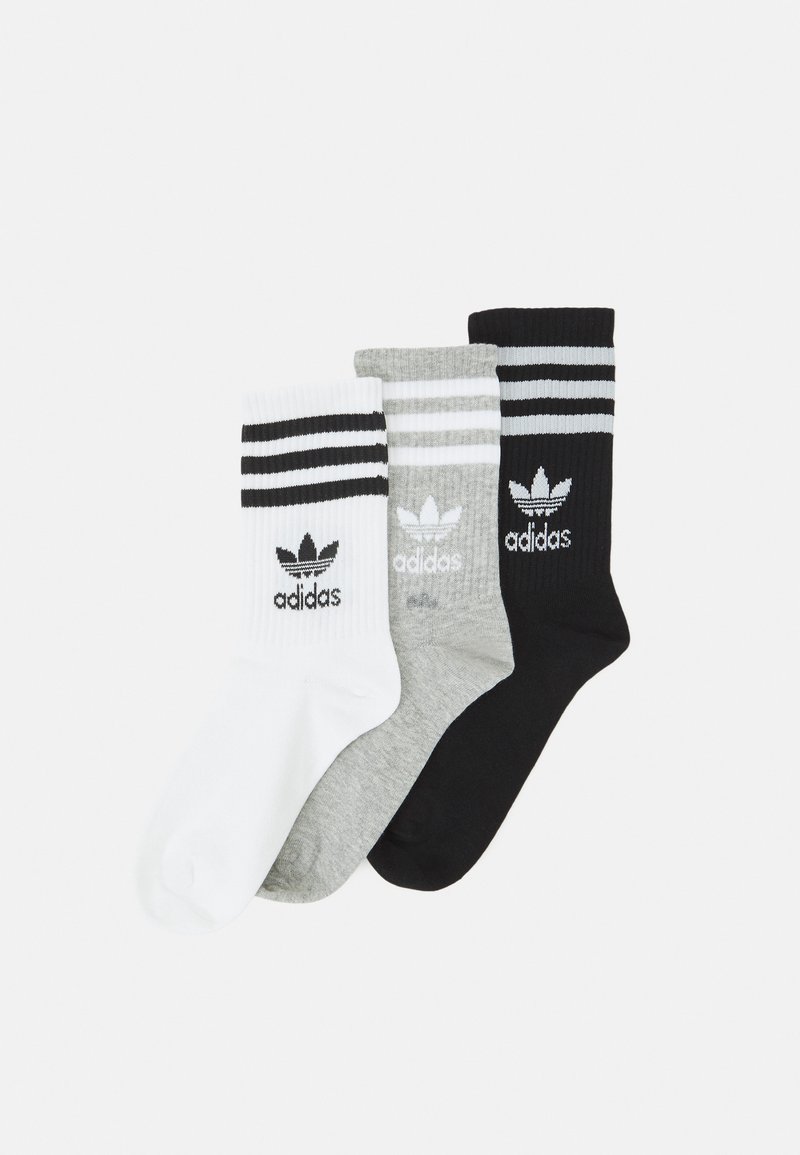 Trzy pary skarpetek sportowych w kolorze białym, szarym i czarnym. Każda skarpetka ma ribbowane ściągacze z trzema poziomymi paskami oraz logo Adidas.
