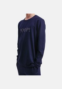 Navyblaues Langarmshirt aus weichem Stoff, mit rundem Halsausschnitt und grauem „JOOP!“-Logo auf der Vorderseite. Lockere Passform und lässiges Design.