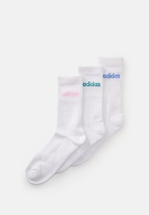 Trois chaussettes blanches de sport avec des revers côtelés, chacune présentant le logo Adidas en broderie rose, verte et bleue près du haut.