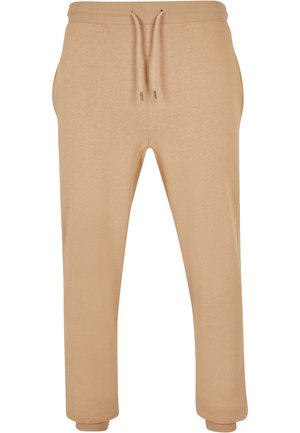 Beige pamut joggingnadrág, rugalmas derékrésszel, állítható zsinórral, oldalsó zsebekkel és tapered szárakkal a bokán.