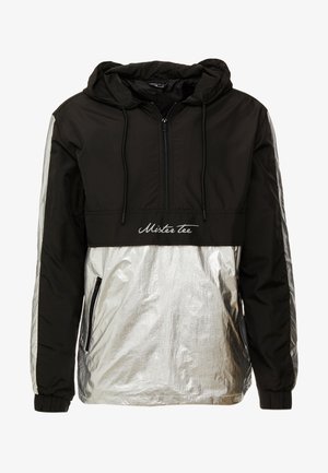 Jachetă neagră tip pulover cu o secțiune inferioară reflectorizantă argintie, fermoar frontal, glugă ajustabilă și manșete elastice. Prezintă logo-ul "Mister Tee".