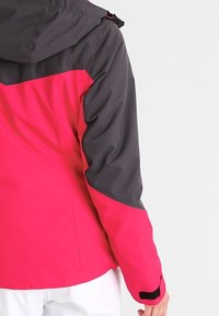 Giacca impermeabile con corpo di un vivace rosa e maniche grigie scure, dotata di cappuccio e polsini regolabili per una vestibilità sicura.