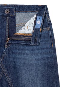 Cinturilla de jeans azul oscuro que muestra una banda elástica ajustable desabrochada con botón y cremallera abierta.