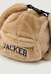 Hnedá umelá kožušina s voľnými ušnými klapkami, na prednej strane s vyšitým čiernym logom "JACKER". Súčasťou je nastaviteľný čierny popruh.