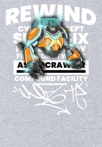 Šedá tkanina se stylizovanou grafikou zobrazenou s oranžovým a modrým robotem, obklopeným bílým textem a prvky grafity.