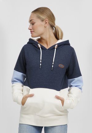 Hoodie bleu marine avec des accents crème et bleu clair. Comprend une capuche avec cordon, des poches avant et un tissu texturé avec un patch logo.