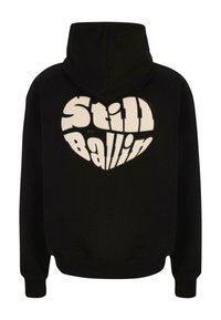 Czarna bluza z kapturem z dużym białym graficznym sercem oraz napisem "Still Ballin" w pogrubionych, zaokrąglonych literach na plecach.