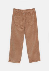 Pantalon en velours côtelé de couleur marron clair avec une taille élastique, comportant deux poches arrière et une texture verticale côtelée sur le tissu.
