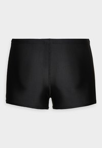 Bermuda de bain noire en matériau lisse et extensible. Caractéristiques d'un design simple et ajusté avec une taille mi-haute et sans accents visibles.