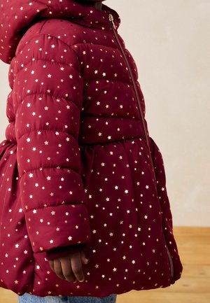 Blouson matelassé bordeaux avec une taille ajustée, arborant des motifs d'étoiles dorées, une fermeture éclair et une capuche. Texture douce avec un design matelassé.