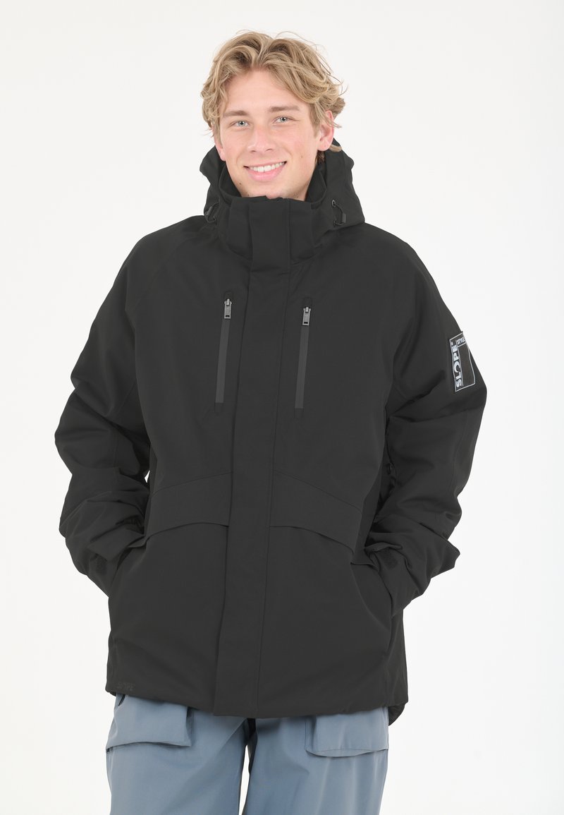 Musta vedenpitävä takki korkealla kauluksella, kahdella vetoketjullisella etutaskulla ja säädettävillä hihansuilla. Suunniteltu ulkoilma-aktiviteetteihin, teksturoitu kangas.