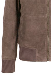 Brązowy zamszowy rękaw i przód kurtki z prążkowanym mankietem i pasem w talii oraz widocznym srebrnym zamkiem z przodu.