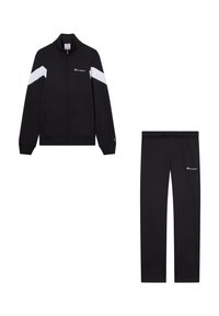 Tuta nera con giacca a zip dotata di strisce bianche sulle spalle e logo. Pantaloni neri abbinati con elastico in vita e dettagli con logo.