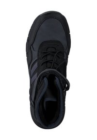 Chaussure de sport noire avec une tige texturée, présentant des rayures grises, un collier rembourré et un intérieur sombre contrastant. Lacets visibles à l'avant.